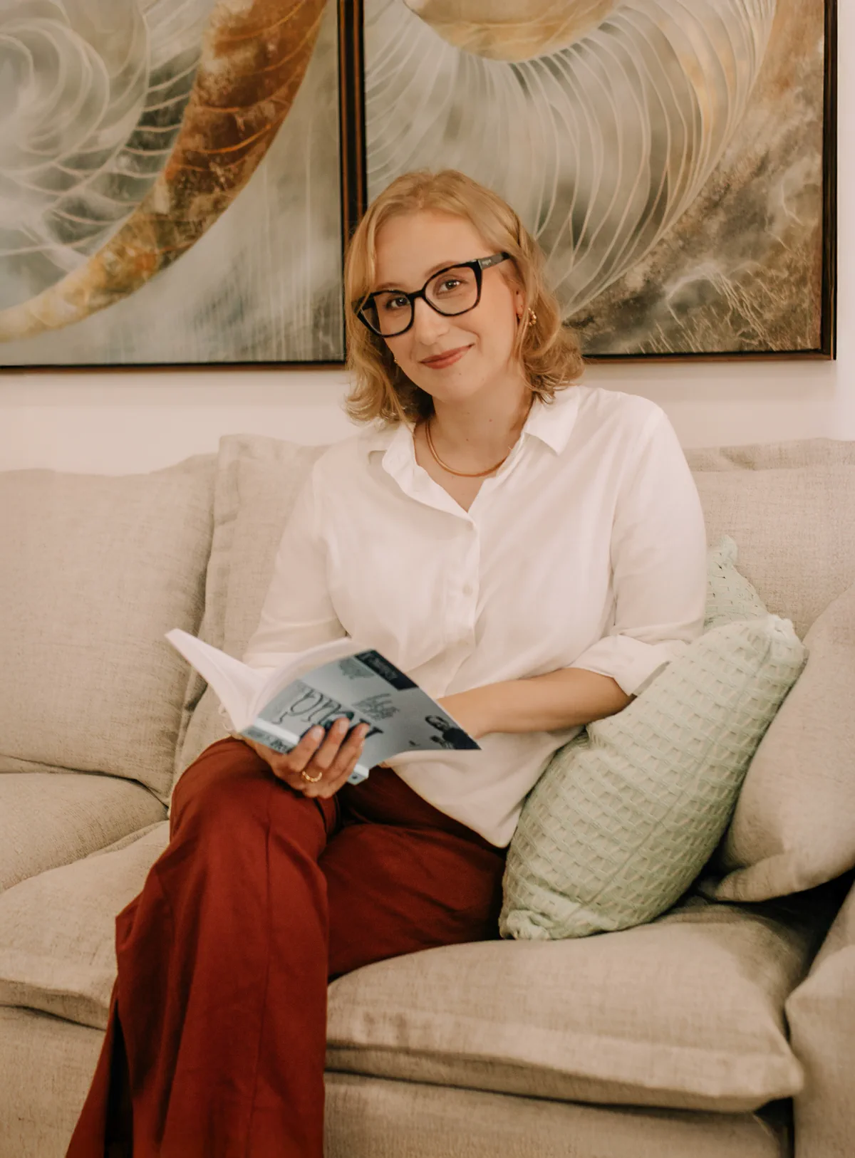 Caroline sentada no consultório com um livro